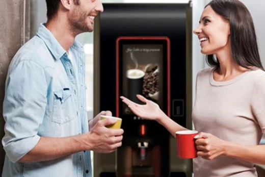 freestanding office coffee machine with people enjoying a hot beverage